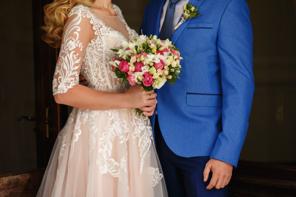 婚礼当天，新郎新娘手捧五彩缤纷的婚礼花束图片下载