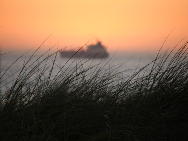 日落时，船在地平线上图片下载