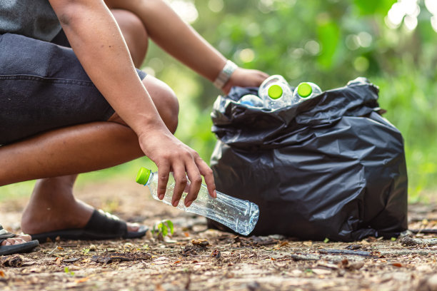 一个人在森林里收集垃圾。保护自然的理念。图片下载