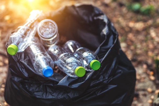 塑料瓶在黑色的塑料垃圾地上。图片下载