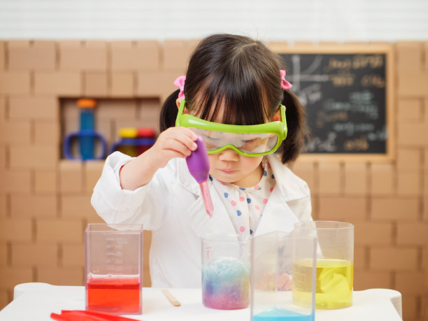 蹒跚学步的女孩假装扮演科学家角色在家上学图片下载