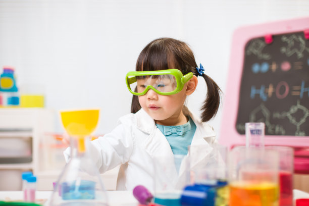 蹒跚学步的女孩假装扮演科学家角色在家上学图片下载