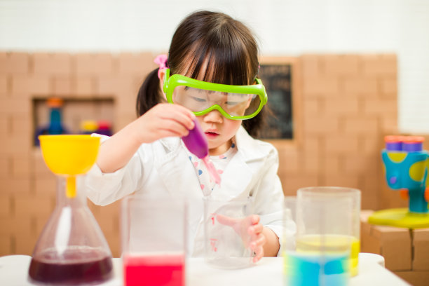 蹒跚学步的女孩假装扮演科学家角色在家上学图片下载