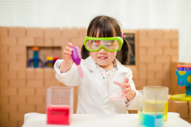 蹒跚学步的女孩假装扮演科学家角色在家上学图片下载