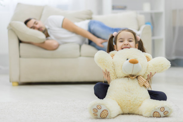 爸爸正在睡觉，爱做梦的女儿在旁边微笑。图片下载