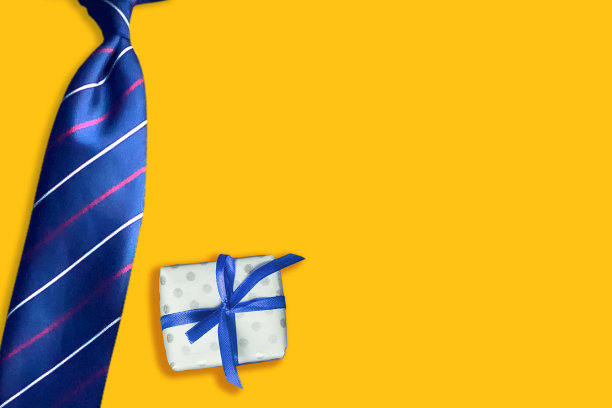黄色背景的领带和礼物。副本的空间。父亲节快乐背景。贺卡。图片下载