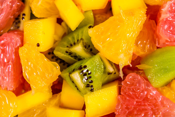 切碎的异国水果的背景。芒果，橙子，柚子和猕猴桃图片下载