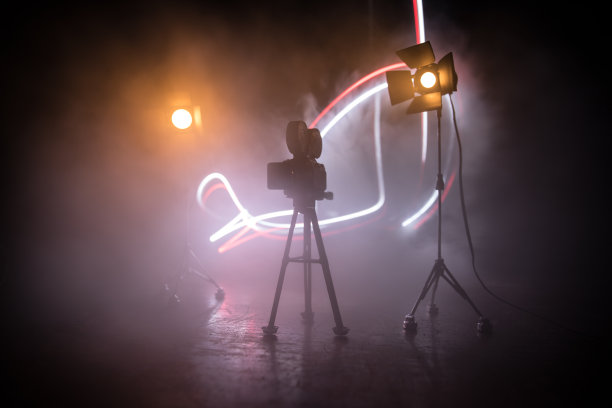 电影的概念。微型电影设置在黑暗色调的背景与雾和空白空间。三脚架上老式相机的剪影。图片下载