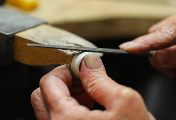 珠宝商用锉刀把银戒指磨平。图片下载