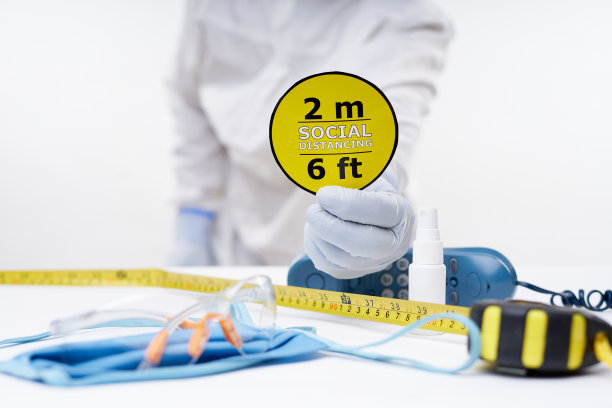 手持白色防护手套的手拿着电话。医用口罩，洗手液喷雾图片下载