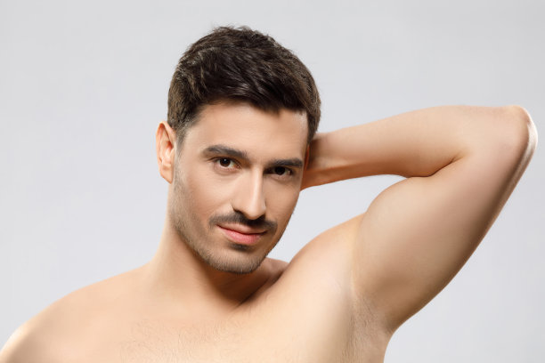 年轻英俊，肌肉发达，短发，鬃毛和裸露的肩膀。男性美容护肤理念，孤立于灰色背景之上图片下载