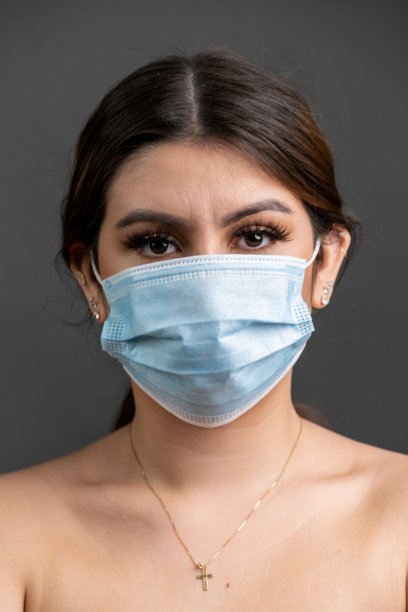 年轻女子戴着防护口罩看镜头图片下载