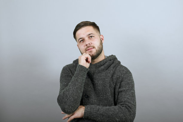 聚焦的男性用食指触摸脸颊并思考。聪明的人,知识分子图片下载