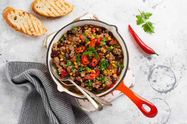 传统的墨西哥食物-红辣椒与碎肉和蔬菜炖番茄酱在一个铸铁平底锅在浅灰色石板或混凝土背景。顶部视图与复制空间。图片下载