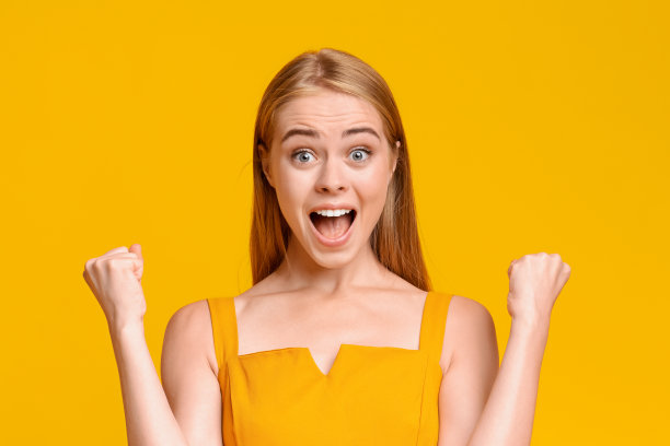 大赢。欣喜若狂的少女情绪喜悦的成功与高举的拳头图片下载