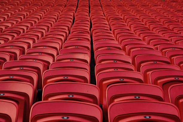 空荡荡的体育场里空荡荡的红色塑料座椅。看台上有许多供观众坐的空座位。为足球迷准备的空塑料椅。图片下载