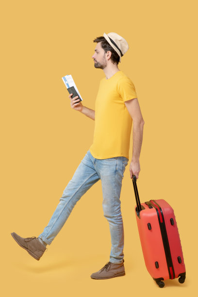 戴着帽子，穿着牛仔裤，带着票和行李箱的男人。图片下载