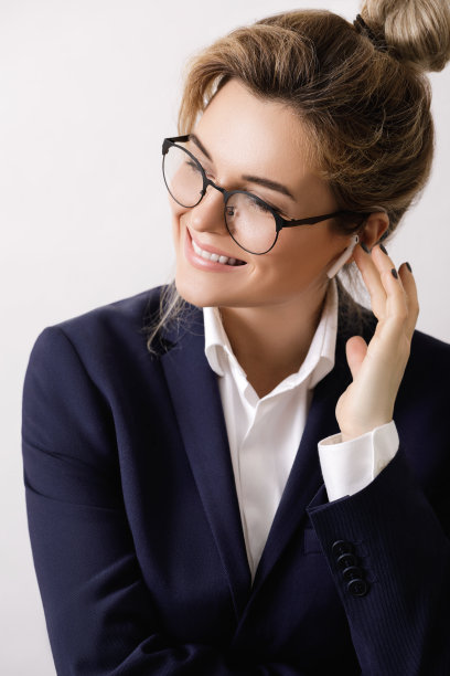 耳朵里戴着无线耳机的女商人图片下载