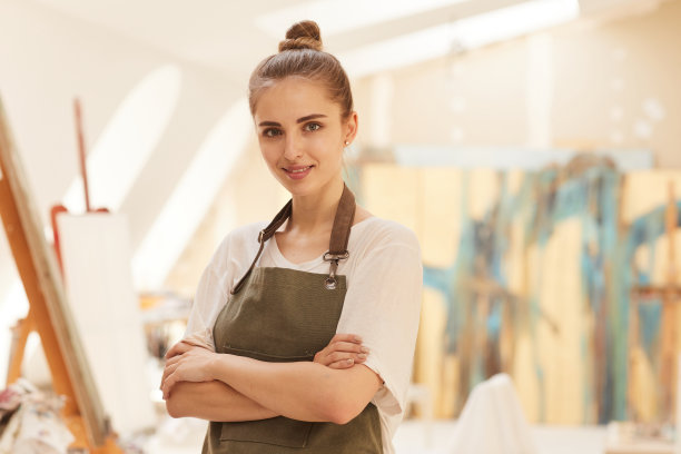 微笑的女艺术家在艺术工作室摆姿势图片下载