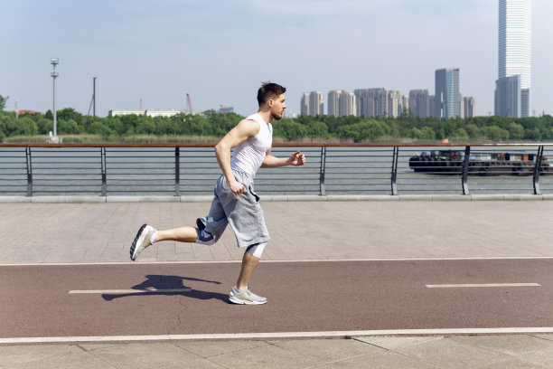 一个健康的年轻人在河边跑步。图片下载