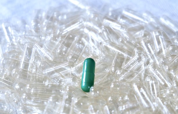 空胶囊堆上的草药图片下载