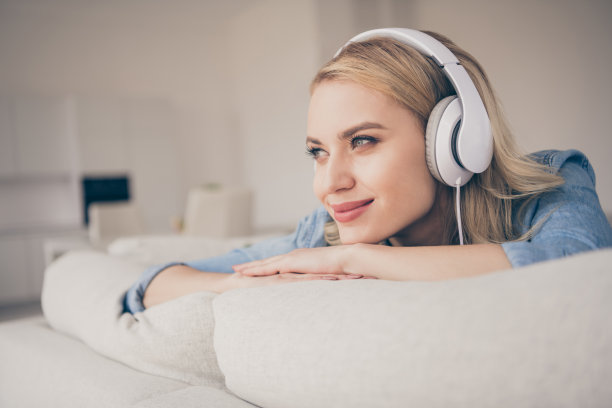 家庭迷人的金发女士的特写照片想念去户外坐在舒适的沙发呆在家里的手听凉爽的耳机，梦想家看窗户隔离时间客厅室内图片下载