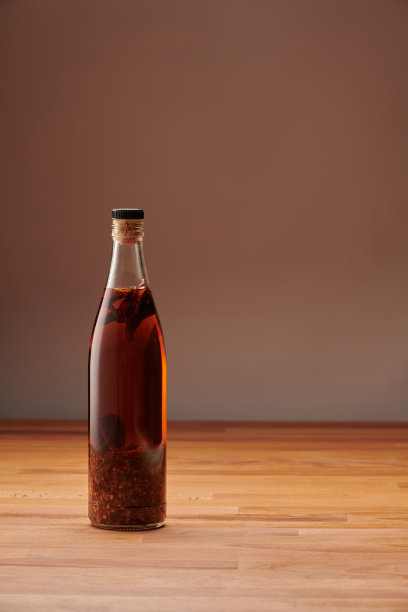 一瓶自制的透明辣椒油，里面有干辣椒片图片下载