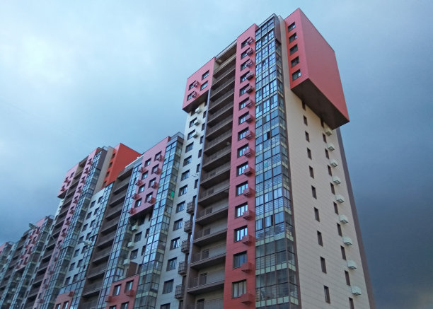暴风雨天空下的现代新建筑明亮外墙图片下载