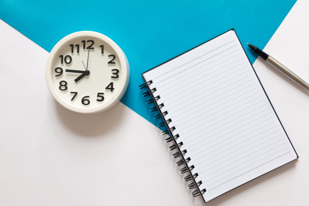 空白笔记本，钢笔和圆形闹钟图片下载