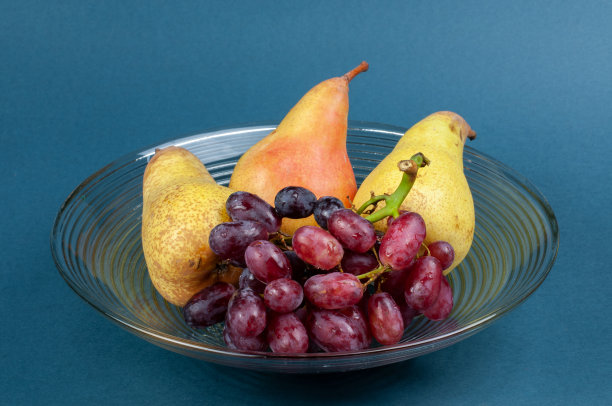 把葡萄和梨放在玻璃碗里吃图片下载