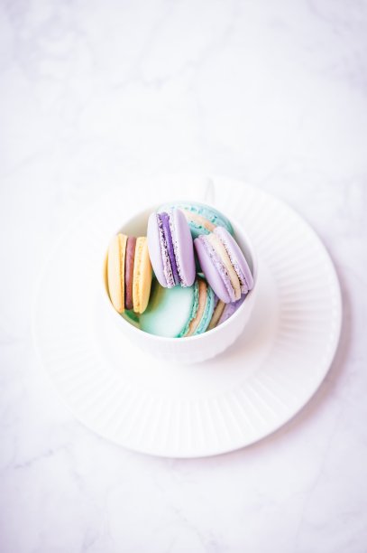 白色大理石背景上的甜彩色蜡笔马卡龙图片下载