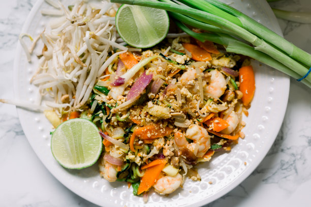 一盘美味的泰式虾粉，由西葫芦面条、胡萝卜条、虾、豆芽和碎花生制成。这是蔬菜泰式炒面配海鲜。图片下载
