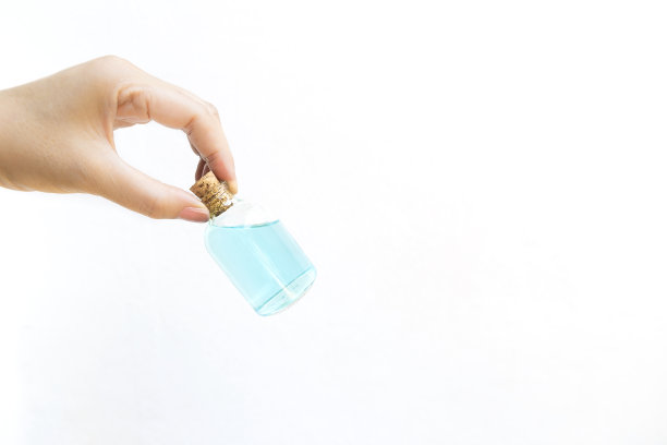 白色背景下，女孩手拿酒精酒瓶图片下载