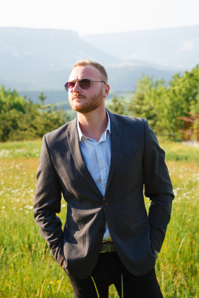 年轻的新郎穿着婚纱，背景是群山。图片下载