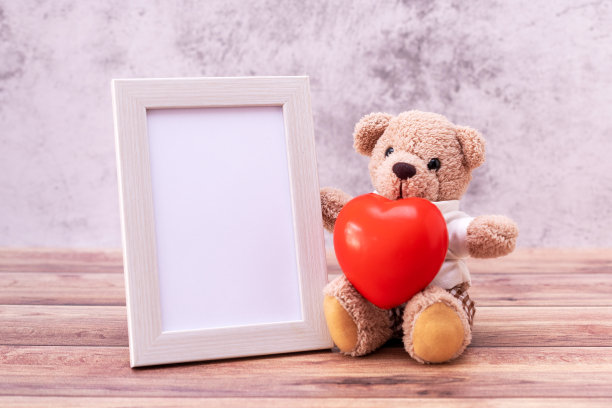 木制桌子上有相框的泰迪熊。情人节庆祝活动图片下载