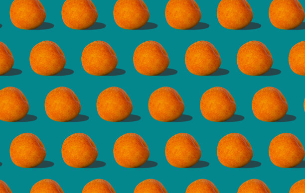 杏黄色的规则图案与坚硬的阴影平铺在柔和的蓝绿色背景上。创意布局夏日水果。图片下载