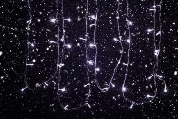 圣诞和新年装饰灯，花环在下雪与小Led灯闪烁在黑色的背景。图片下载