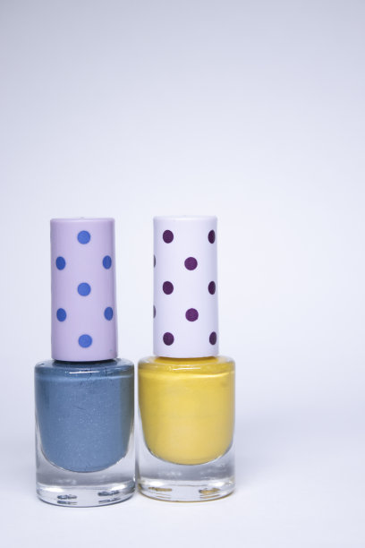 瓶子与蓝色和黄色指甲油在白色的背景。指甲上漆。指甲修指甲的概念。孤立的,复制空间图片下载
