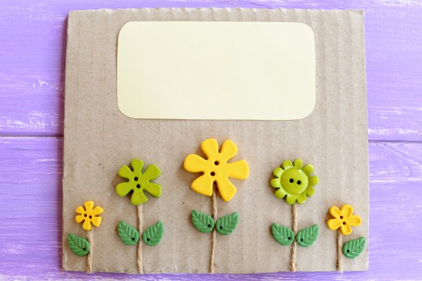 可爱的贺卡与塑料花和树叶。带有装饰按钮和空白文本位置的卡片。纸板箱和纽扣工艺创意图片下载