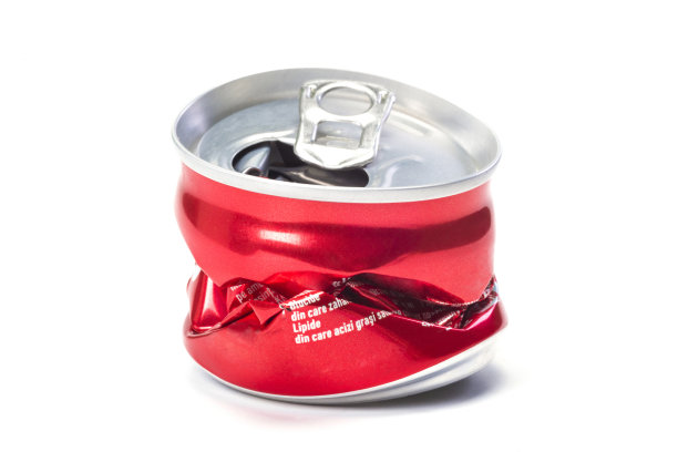 一个红色的空铝碎罐在白色的背景，一个特写。图片下载