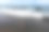航拍一名身穿红色比基尼和草帽的女子走在黑色沙滩上。在巴厘岛度假。从无人机的照片图片下载