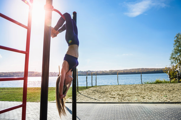 年轻女子在墙上锻炼的照片。健身妇女锻炼她的腹肌与吊腿抬高。健康。图片下载