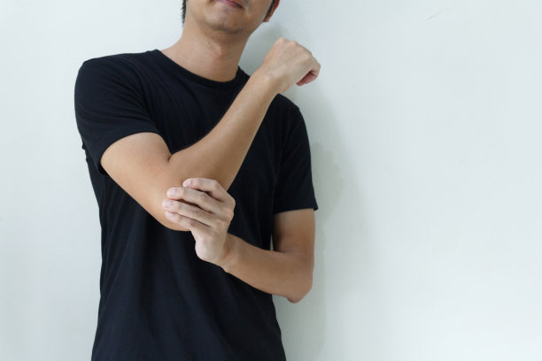 年轻人在家里肘部受伤疼痛。卫生保健的概念。图片下载