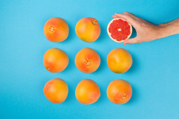 创意健康饮食的最小概念与葡萄柚安排在蓝色平坦的背景图片下载