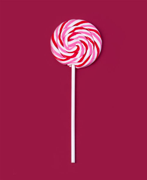 红色背景上的彩色棒棒糖。图片下载