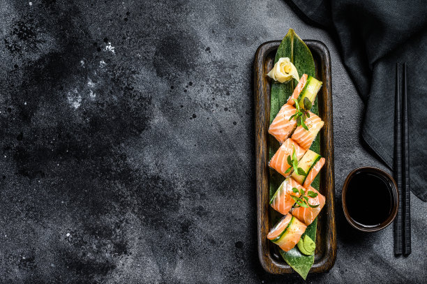 费城寿司卷配鲑鱼，鳄梨，奶油芝士。寿司菜单。日本的食物。黑色背景。前视图。本空间图片下载