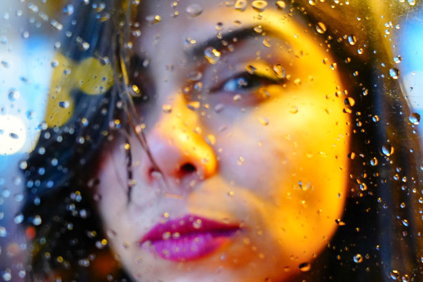 年轻女子的手在雨中的窗口忧郁而悲伤图片下载