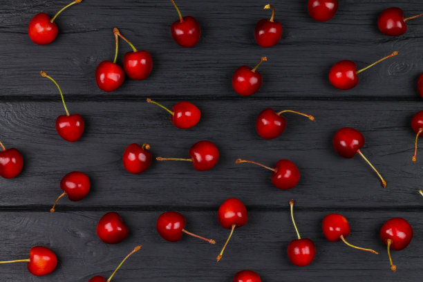 成熟的红樱桃散落在桌子上。图片下载