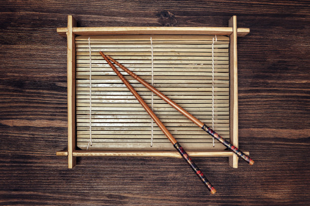 竹托盘和筷子放在一个深色的木桌上图片下载