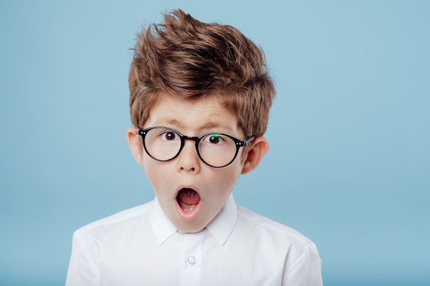 惊讶的小男孩戴着蓝色的眼镜图片下载